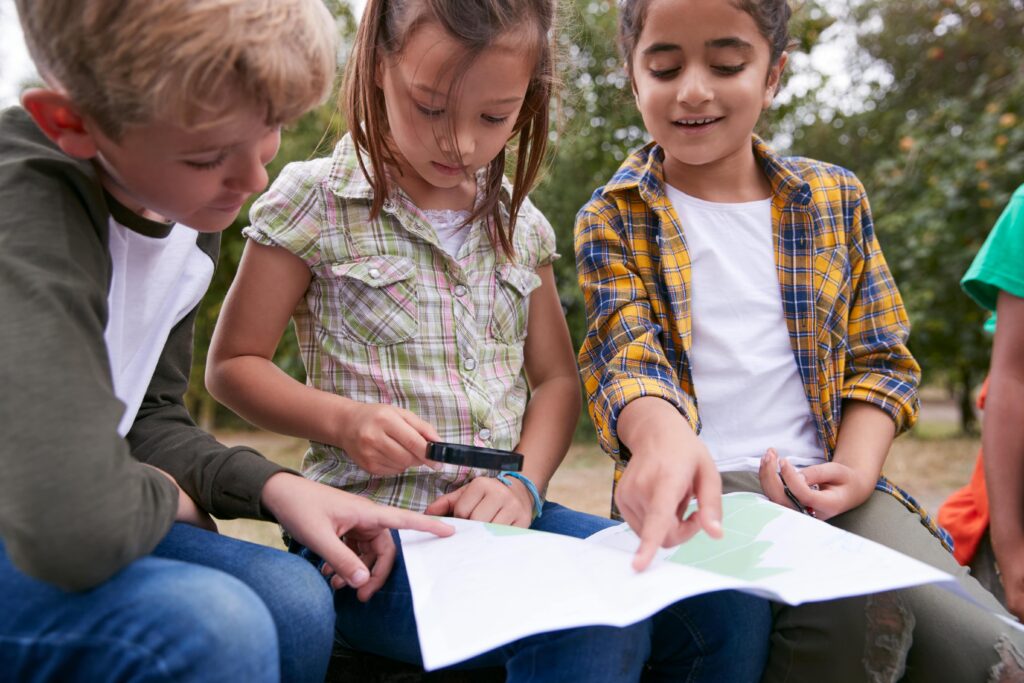 3 kids looking at a book